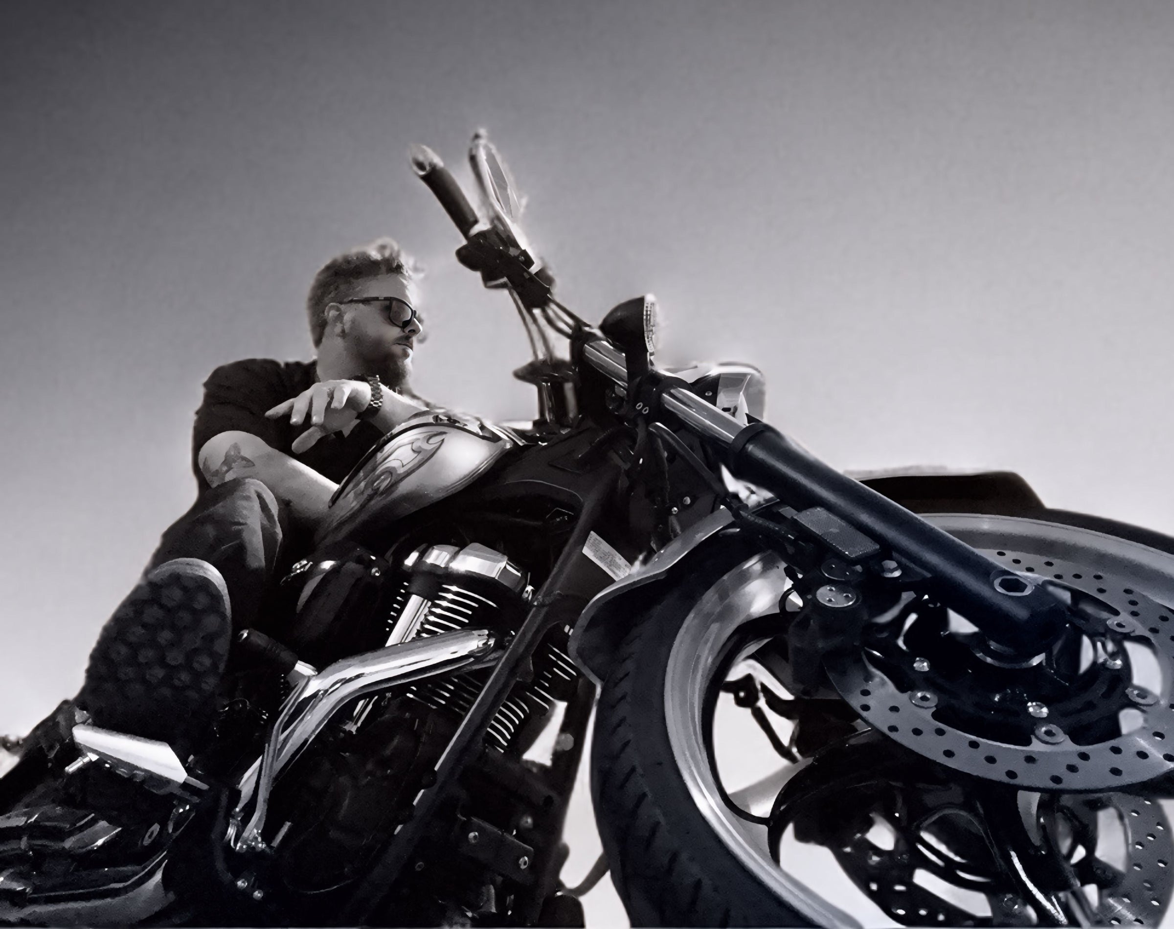 Man sitting on a motorcycle with a clear sky background